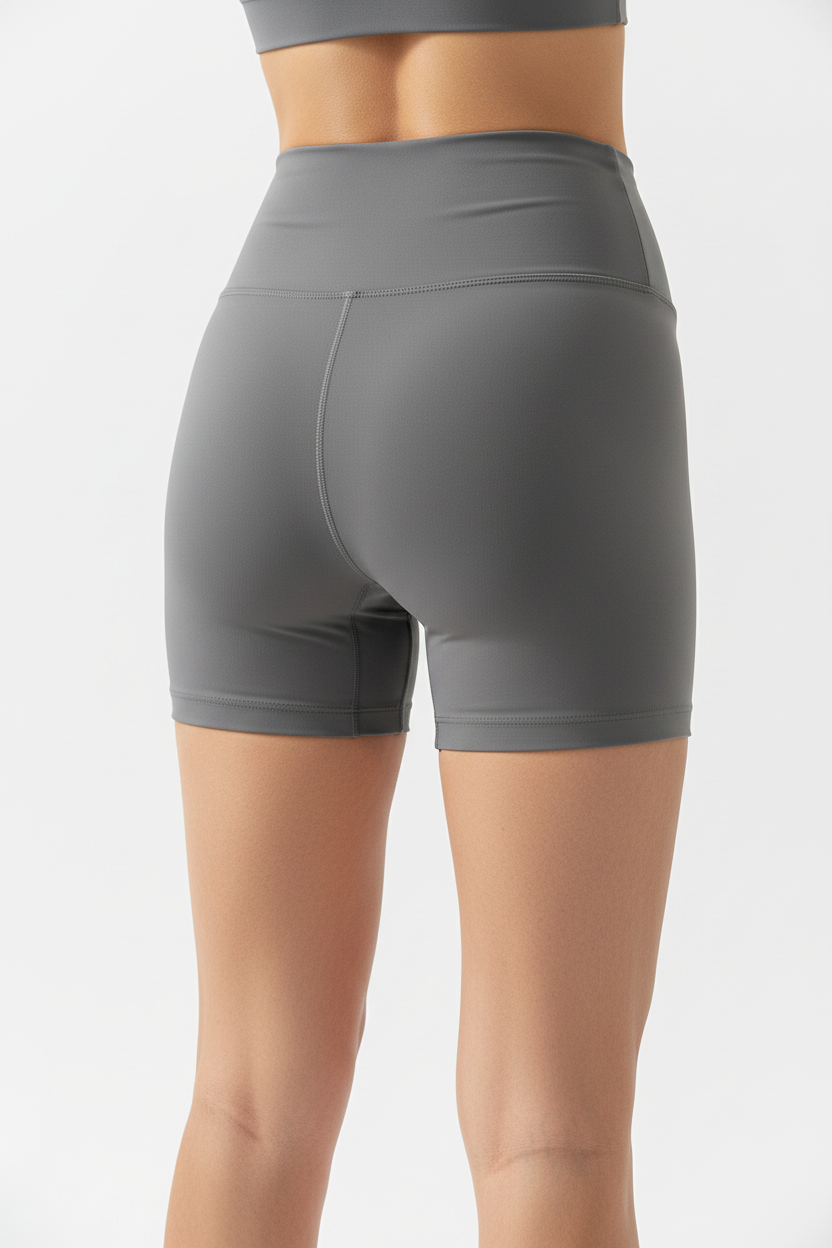 Model wearing graphite gray high-waist sports shorts